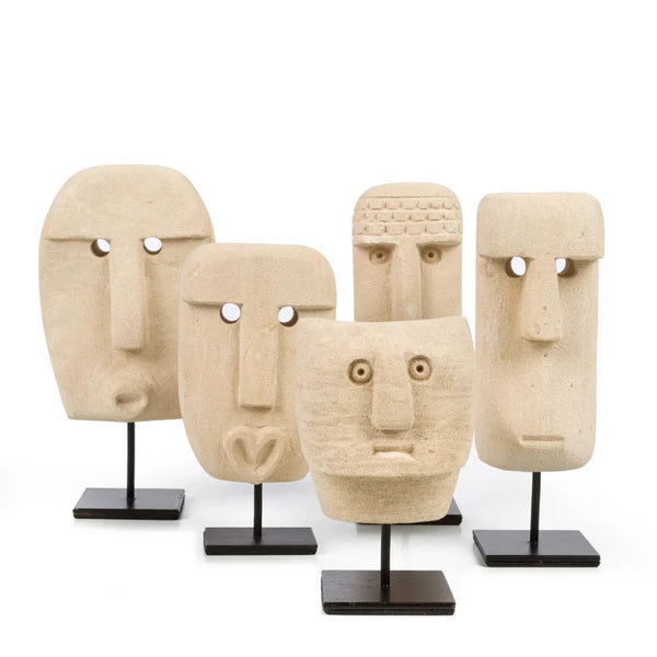 Set of five stone-like face sculptures on stands against a white background