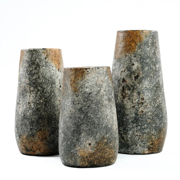 Three rustic stone vases on a white background