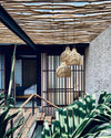 Indoor setting with woven pendant lights, wooden ceiling, and plants.