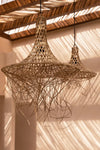 Woven rattan pendant light hanging from a wooden ceiling
