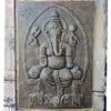 Carved stone panel of a deity with architectural elements on a textured wall.