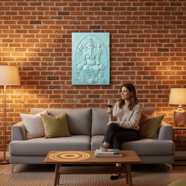Woman sitting on a couch in a cozy living room with a brick wall and decorative wall art.
