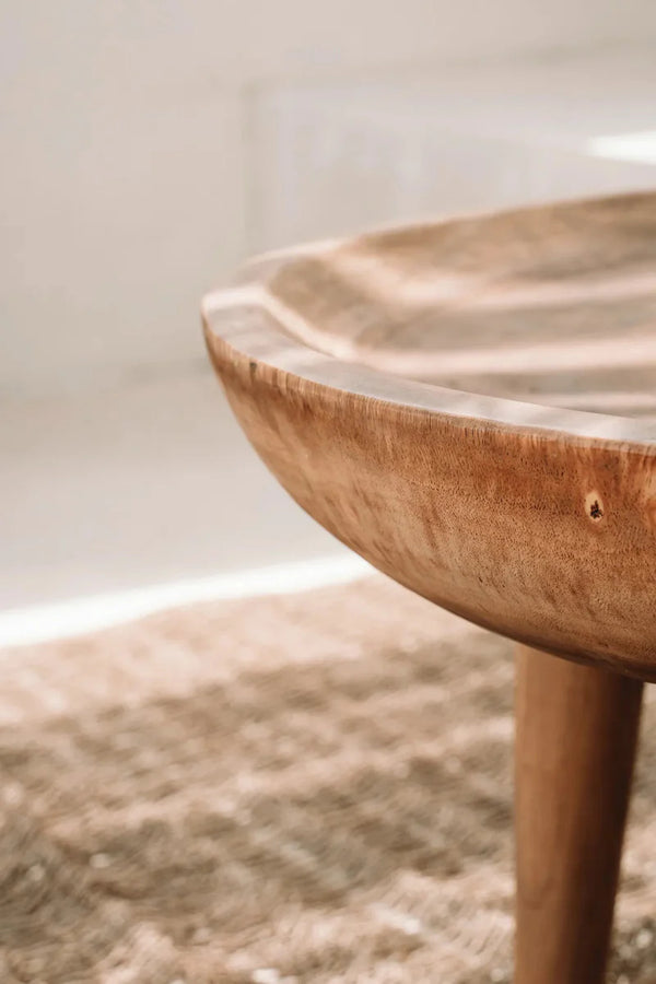 Wooden side table with a textured surface on a neutral background