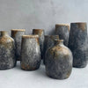 Set of rustic ceramic vases on a light surface with a gray background