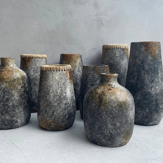 Set of rustic ceramic vases on a light surface with a gray background
