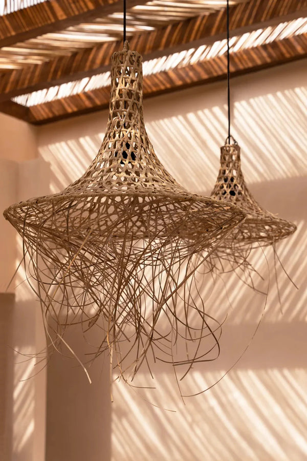 Woven rattan pendant light hanging from a wooden ceiling