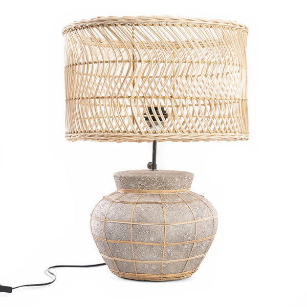 Table lamp with wicker basket shade and textured base on a white background