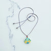 Necklace with a colorful pendant on a marble surface