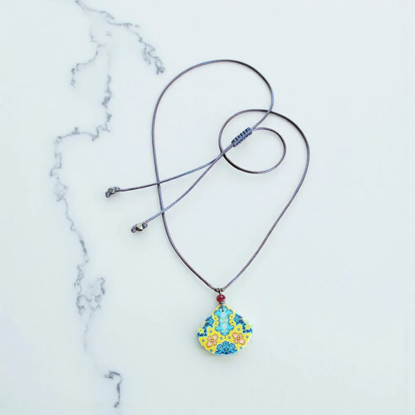 Necklace with a colorful pendant on a marble surface