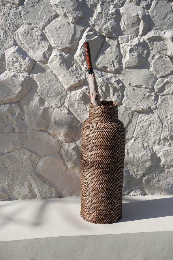 Woven bottle with a knife on a stone wall background
