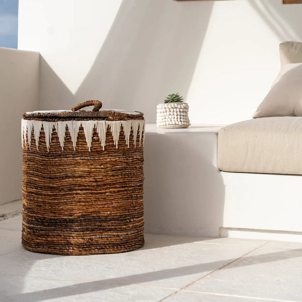 Woven basket on a white patio with a white wall and window in the background