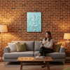Woman sitting on a couch in a cozy living room with a brick wall and decorative wall art.